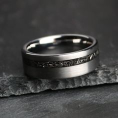 a wedding band that has been made with white gold and black diamond inlays