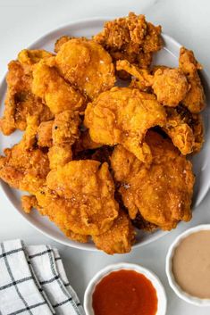 a white bowl filled with fried chicken on top of a table