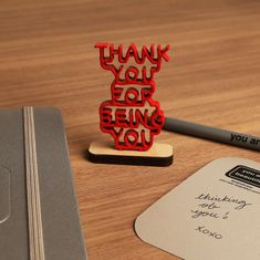 a thank you for being you rubber stamp sitting on top of a desk next to a notepad