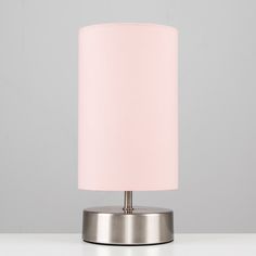 a pink lampshade sitting on top of a white table