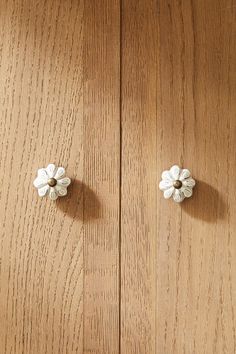 two wooden doors with white flowers on them