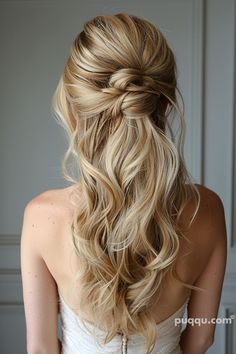 a woman with long blonde hair wearing a wedding dress and braided in half - up