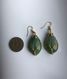 A pair of big charming teardrop-shaped green or pink hanging earrings, with gold wired tree of life wire wrapped artistically on the green or jade stones. They are so unique and eye-catching, hard to not notice when you wear them. Some highlights of these lovely gold family tree jade earrings are: *High-quality materials Quality green or pink jade stones, hand-wired in the tree of life wires. *Eye-catching design Simple and unique. The tree of life symbolizes the previous life, harmony, and fami Teardrop Copper Wire Jewelry For Gifts, Bohemian Teardrop Copper Wire Jewelry, Green Teardrop Nature-inspired Jewelry, Nature-inspired Green Teardrop Jewelry, Green Wire Wrapped Crystal Earrings As Gift, Handmade Green Teardrop Earrings, Green Wire Wrapped Crystal Earrings For Gift, Green Bohemian Earrings With Copper Wire, Bohemian Green Earrings With Copper Wire