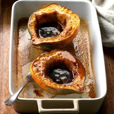 two squash halves in a baking dish with sauce