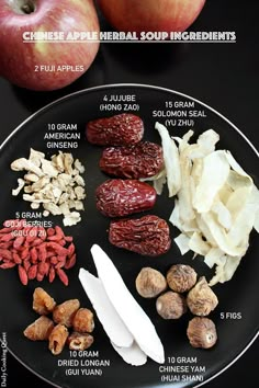 an apple, raisins, almonds and other ingredients on a black plate