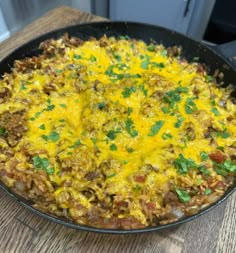 a skillet filled with food sitting on top of a wooden table