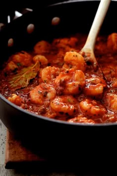 a skillet filled with shrimp and tomato sauce