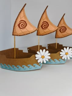 two paper boats with white flowers on them