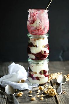 three jars filled with food sitting on top of a wooden table