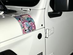 a white jeep with flowers on it's side mirror and door handle sticker