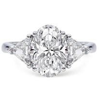 an oval cut diamond ring with three pear shaped diamonds on the shoulders and side stones