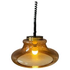 a yellow glass light hanging from a ceiling fixture with a black cord attached to it