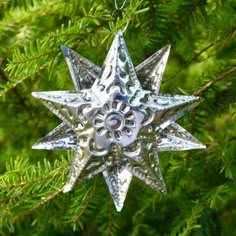 a metal star ornament hanging from a tree