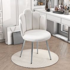 a white chair sitting on top of a wooden floor in front of a desk and mirror