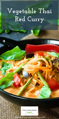 vegetable thai red curry in a black bowl with green garnish on the side