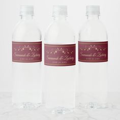 three clear water bottles with labels on them