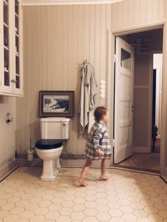 a small child is walking in the bathroom