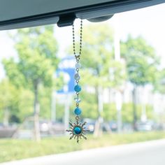 a car dashboard with a sun charm hanging from it's side window