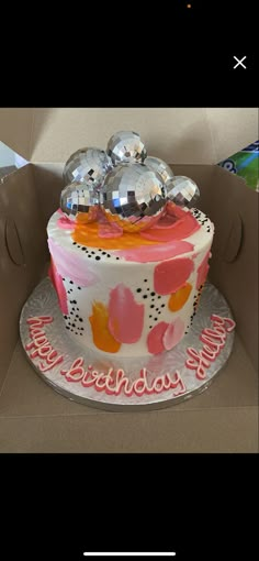 a birthday cake in a box with balloons on top