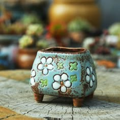 a ceramic flower pot sitting on top of a wooden table