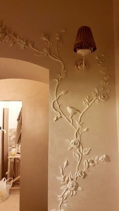 a bathroom with a lamp and flowers on the wall