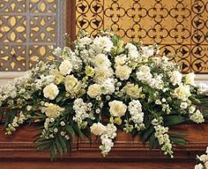 the casket is filled with white flowers and greenery