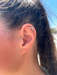 a close up of a person's ear with three piercings