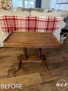 a coffee table that has been turned into a end table with a plaid blanket on top