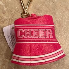 a red cheer hat keychain with the word cheer on it