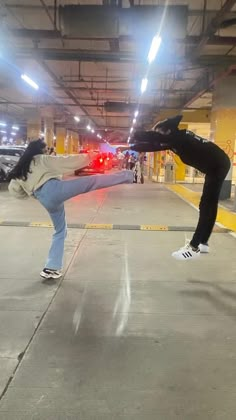 two people doing tricks on skateboards in a parking garage with their feet off the ground