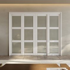 an empty room with white walls and glass doors