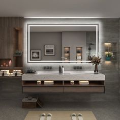 a large bathroom with two sinks, mirrors and lights on the wall above each sink