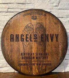 an old wooden barrel sign with two angel wings on the front and back of it that says, angels envy kentucky straight bourbon whisky finisher at the barrels