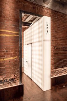 an empty room with brick walls and wooden floors is shown in front of a doorway