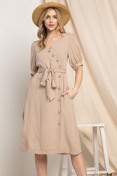 Elevate your wardrobe with our Asymmetrical Button-Down Wrapped Midi Dress, a true embodiment of timeless elegance and style. This dress offers a perfect blend of sophistication and modern flair, ensuring you'll look effortlessly chic and feel confident on any occasion. Key Features: Half-Sleeve Design: The dress features a half-sleeve with button closure, providing a touch of modesty and versatility. You can adjust the sleeves to your preference, making it suitable for various weather condition Cheap Brown Dress With Button Closure, Classic V-neck Midi Dress With Buttons, Elegant Summer Dresses With Covered Buttons, Chic Spring Midi Dress With Covered Buttons, Fitted Midi Dress With Button Back, Fitted Knee-length Midi Dress With Button Back, Elegant Summer Midi Dress With Covered Buttons, Fitted Solid Midi Dress With Button Closure, Spring Midi Dress With Asymmetrical Hem And Belt