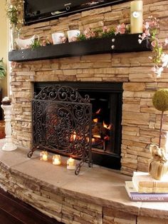 a fireplace with candles and flowers on it