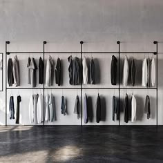 a rack with clothes hanging on it in front of a wall