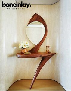 a wooden table with a mirror and vase on it