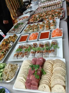 a buffet table filled with lots of different types of food on plates and serving trays