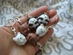 a person holding five small animal key chains