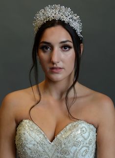 a woman in a wedding dress wearing a tiara