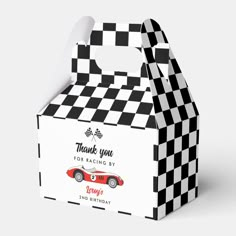 a black and white checkered box with a red car on it