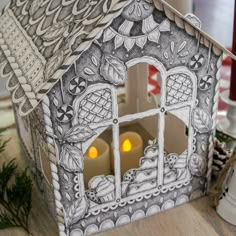 a paper house with candles in it on a table