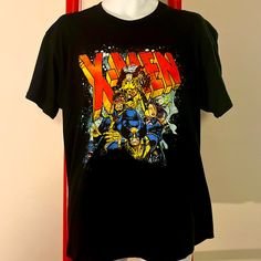 a black t - shirt with the words x - men on it is displayed in front of a mannequin