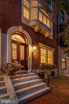 a brick building with stairs leading up to the front door and windows on each side