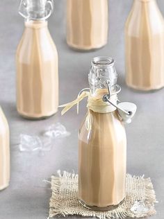 two glass bottles filled with liquid sitting on top of a table next to each other