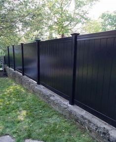 a black fence in the middle of a grassy area