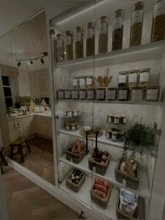 the shelves are filled with many different types of food in jars and glass containers on them