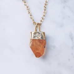 Enchanting Tangerine Quartz raw stone energy necklace in 24K gold plated over brass. Available in women's and men's chain lengths. The Tangerine Quartz stimulates the joyful energy of the inner child, activating playfulness, curiosity and passion. The raw stone crystal will vary slightly in shape, size and color. Crystal Sizes Medium (1 - 1.25 inches) Large (1.25 plus inches) Chain length 16 inches / 40.6 cm 18 inches / 45.7 cm 23.5 inches / 60 cm 31.5 inches / 80 cm Available in 925 Sterling Si Everyday Gold Spiritual Crystal Necklace, Gold Spiritual Crystal Necklace For Everyday, Everyday Spiritual Gold Crystal Necklace, Everyday Gold Charm Necklaces With Natural Stones, Gold Birthstone Necklace For Healing, Healing Gold Birthstone Necklace With Gemstone, Gold Necklaces With Natural Stones For Everyday, Gold Amulet Necklaces With Natural Stones, Everyday Gold Necklaces With Natural Stones