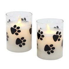 Accent your home with this adorable pair of battery operated Paw Prints flickering flame candles. The natural flickering flame creates the illusion of a real candle. The clear glass includes genuine poured wax and an enclosed flickering LED light with a six hour timer. The flickering flame looks so real and casts natural light, you'll think it's a real flame. Each candle requires 3 AAA batteries (not included). Product Details: - Set of 2 Battery Operated Candles - Wax and Glass Construction - T Glass Candles, Real Flame, Wall Art Lighting, Battery Operated Candles, Solar String Lights, Candle Flames, So Real, Fairy String Lights, Glass Printing